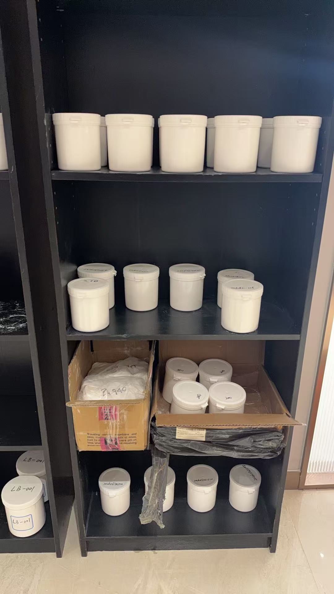 White sample containers on dark shelves